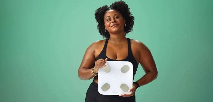 woman holding smart scale and feeling happy about the results